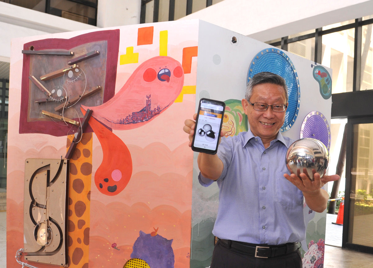 賀陳弘校長在作品「躍動彈珠」投下彈珠，幻變為手機裡的虛擬彈珠，啟動2019「印象清華」躍介科技藝術節