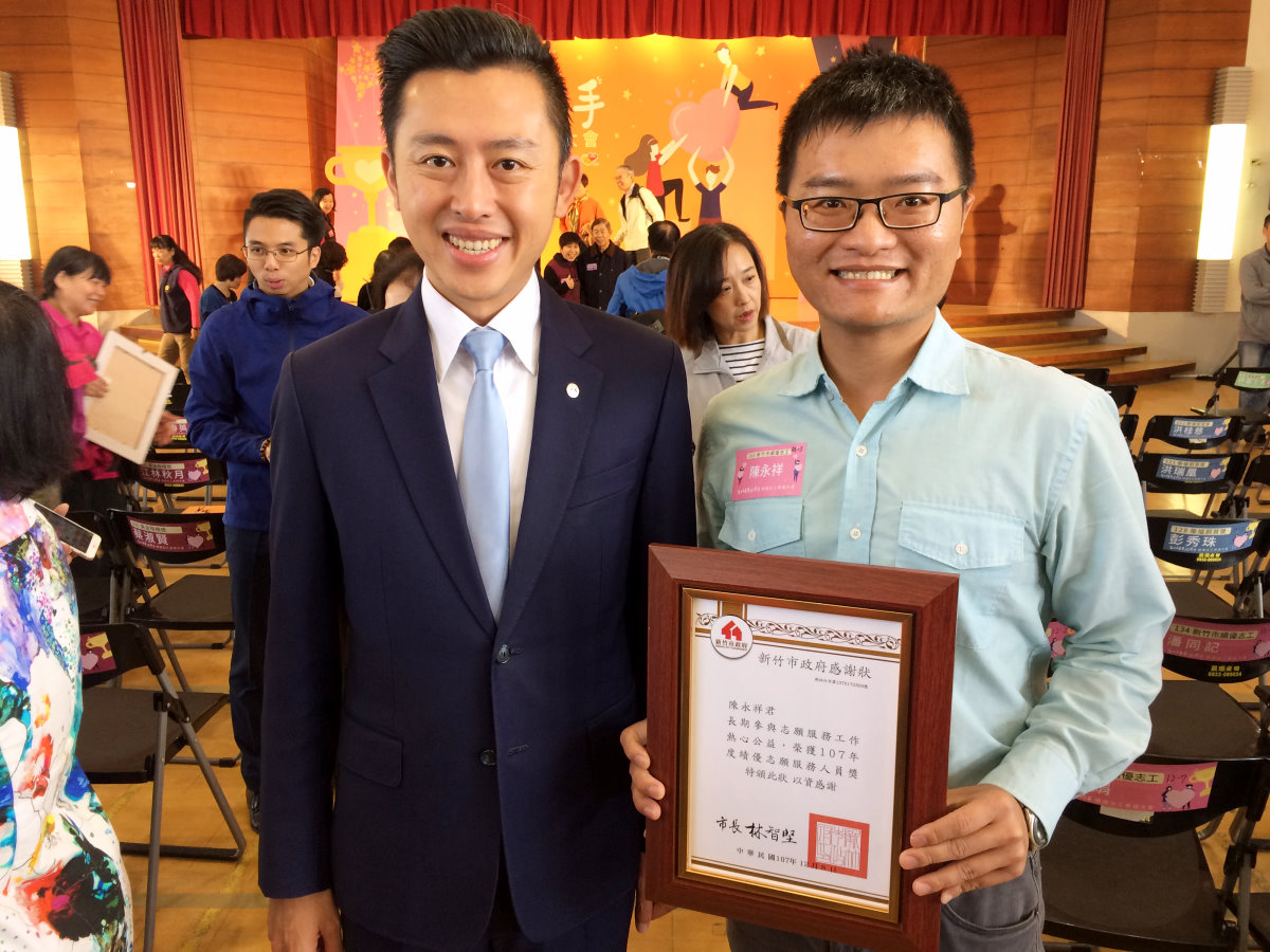 新竹市林智堅市長(左)去年表揚擔任新竹市微笑體育志工的陳永祥(右)為績優志願服務人員