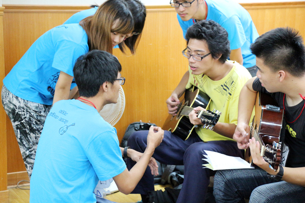 小隊輔正在向小隊員教授吉他彈奏技巧