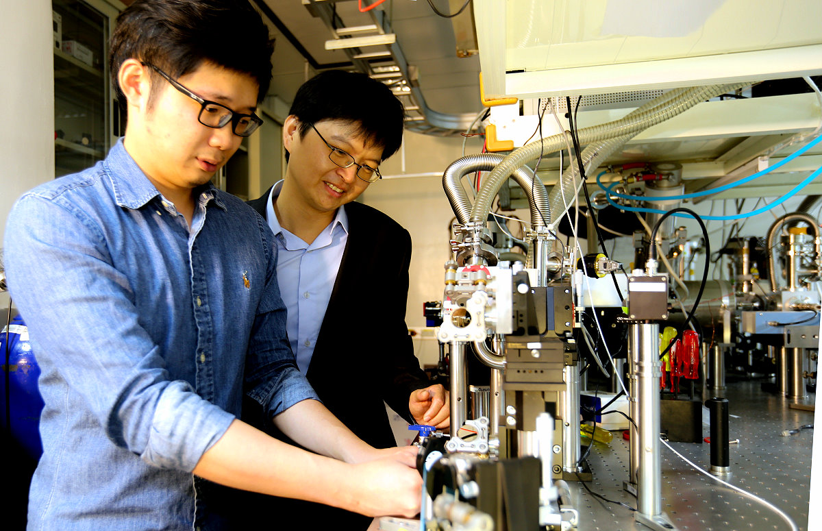 本校光電所助理教授陳明彰(右)與博士班學生黃旆齊(左)，操作桌上型EUV，此項研究也登上光電指標期刊Optica