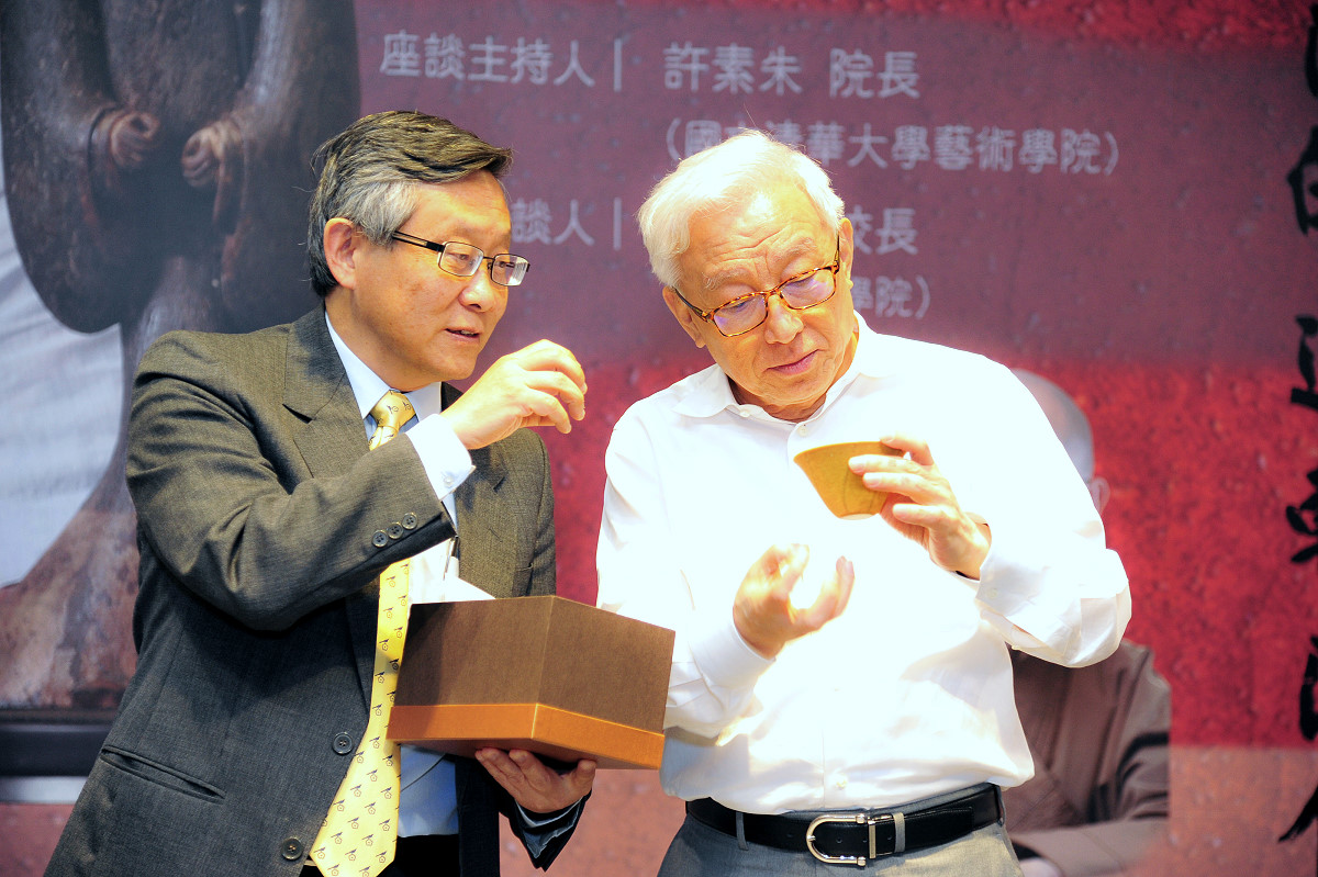 賀陳弘校長(左)致贈用回收玻璃製成的咖啡濾杯給曹興誠先生