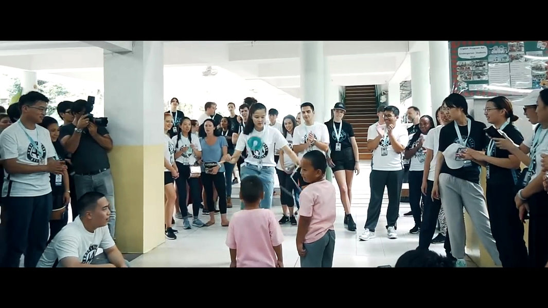 邱怡澍同學以扯鈴與泰國貧民窟的學童互動的畫面，被剪入世界大學生領導大會官方宣傳影片。(翻攝大會影片)