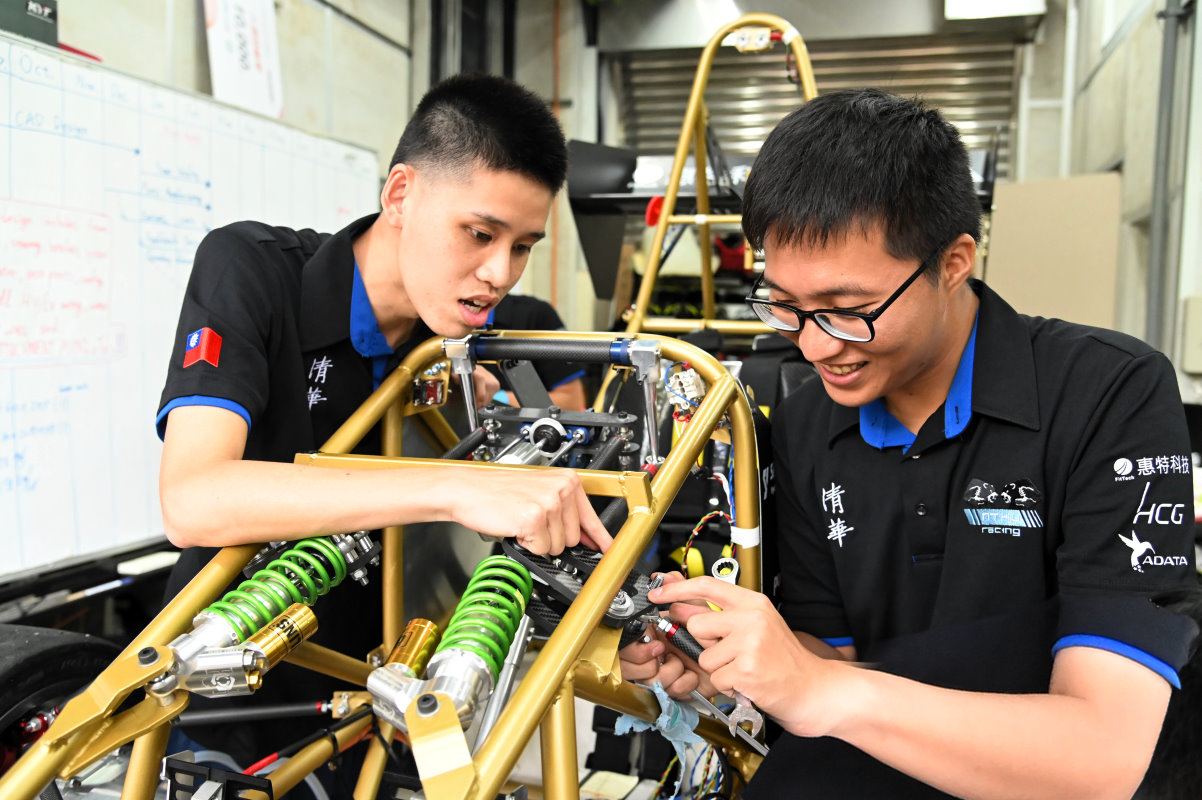 清大賽車工廠成員邱鏡宇(左)與謝昇翰合力組裝電動車