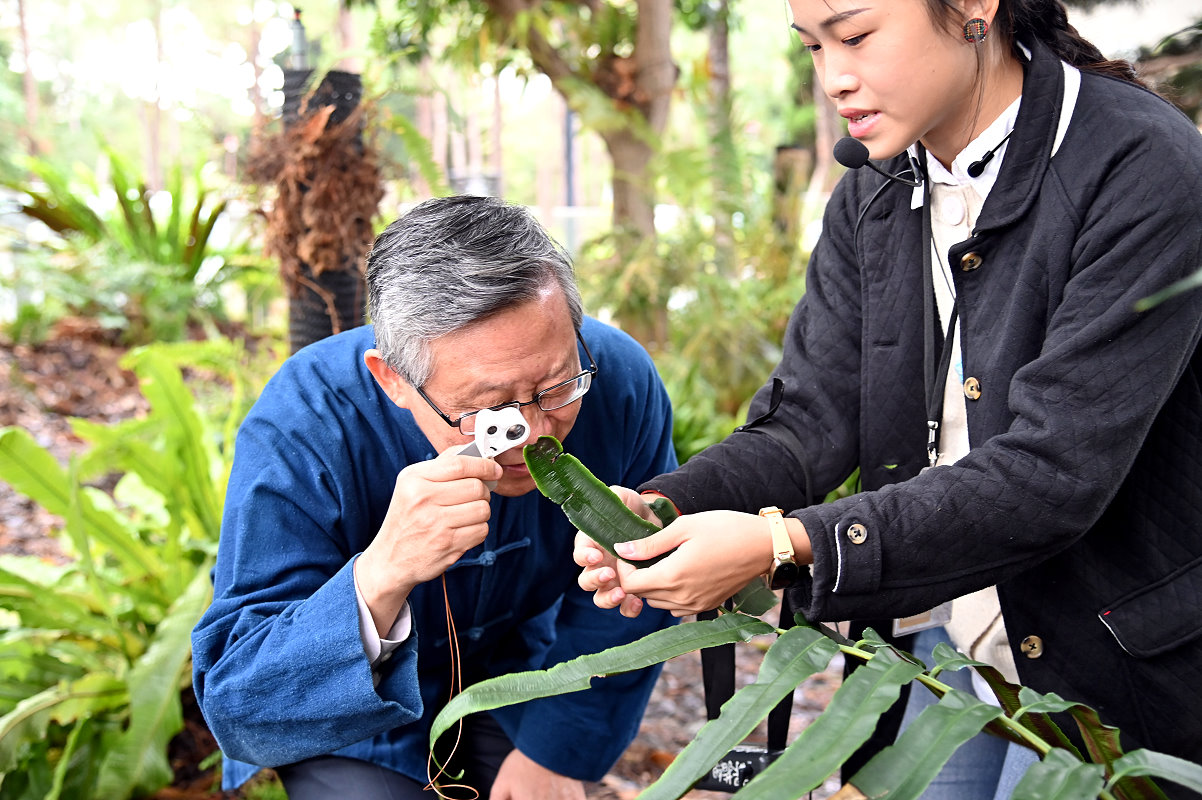 本校賀陳弘校長(左)在學生導覽下，使用放大鏡觀察蕨類孢子
