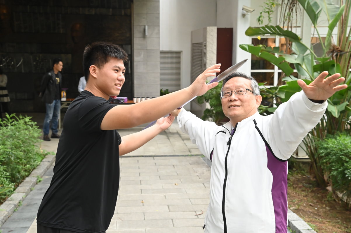 清華行健獎得主郭柏辰(左)指導賀陳弘校長投擲標槍的技巧