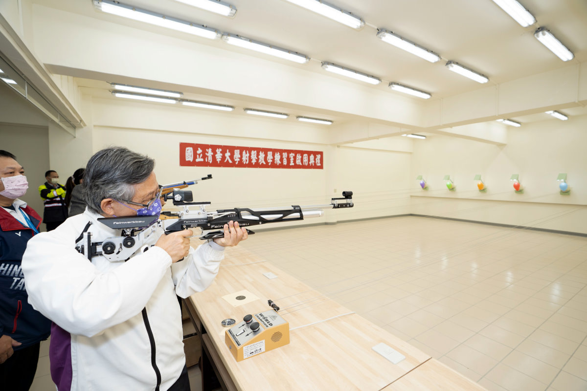 賀陳弘校長在射擊教室啟用典禮率主管持空氣步槍擊破氣球