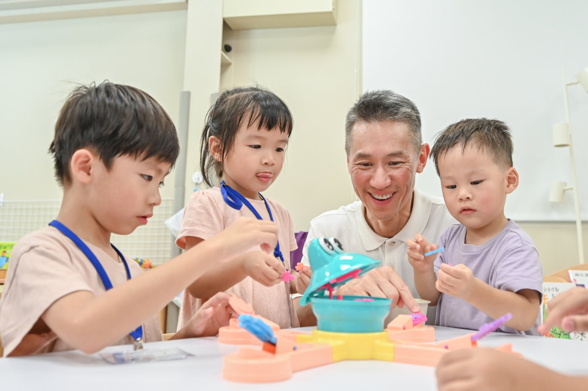 高為元校長(右二)陪小朋友玩餵青蛙的遊戲