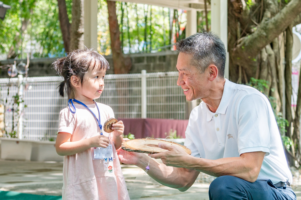 新生代表徐小妹妹準備小木牌遞給高為元校長，請他寫下祝福