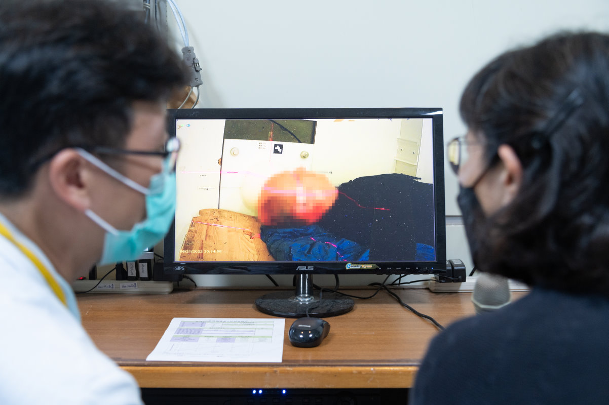 醫師及家屬透過螢幕掌握照射室內的病患狀況