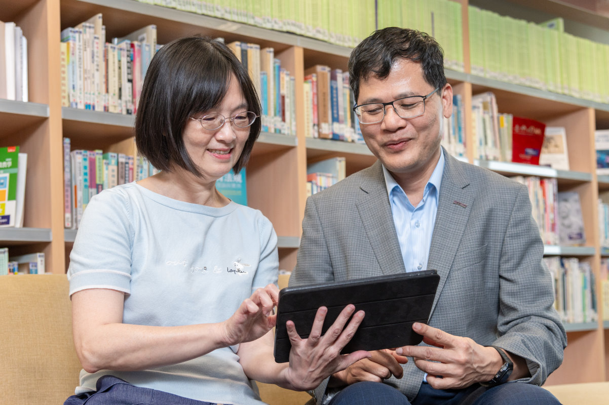本校圖書館林登松館長(右)和資訊系統組林彥君組長討論數位圖書館系統