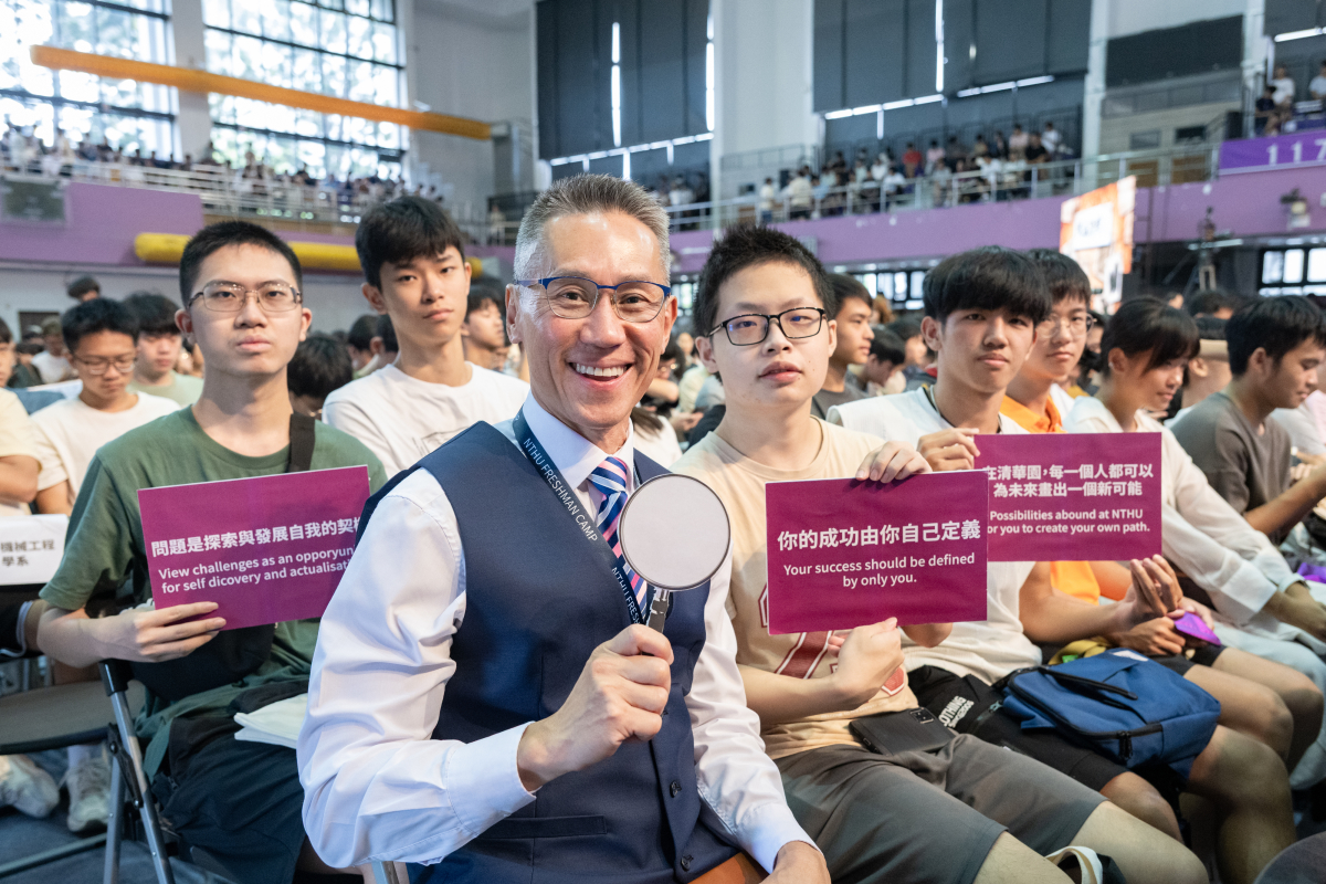 高為元校長巧扮偵探，手持放大鏡道具，與新生坐在一起